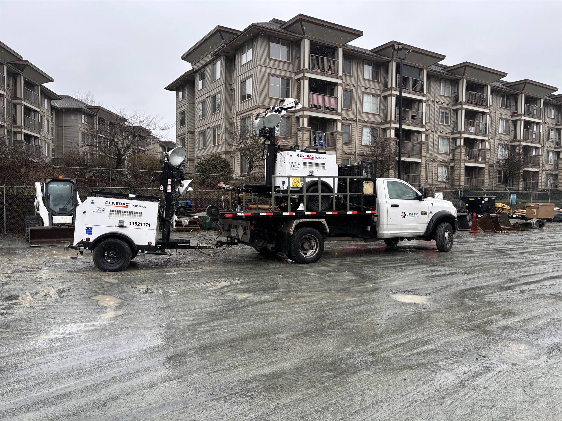 Verbena Transport flatbed truck hauling equipment on a job site